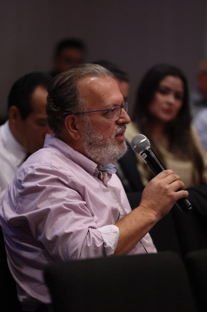 Jefferson Ricardo de Bem speaking into a microphone at an event